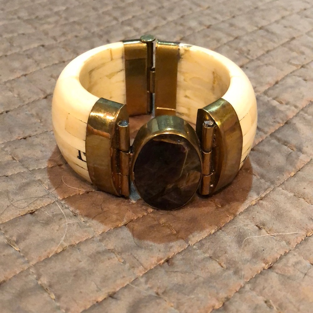 Inlaid, ivory-like bracelet with stone accent.